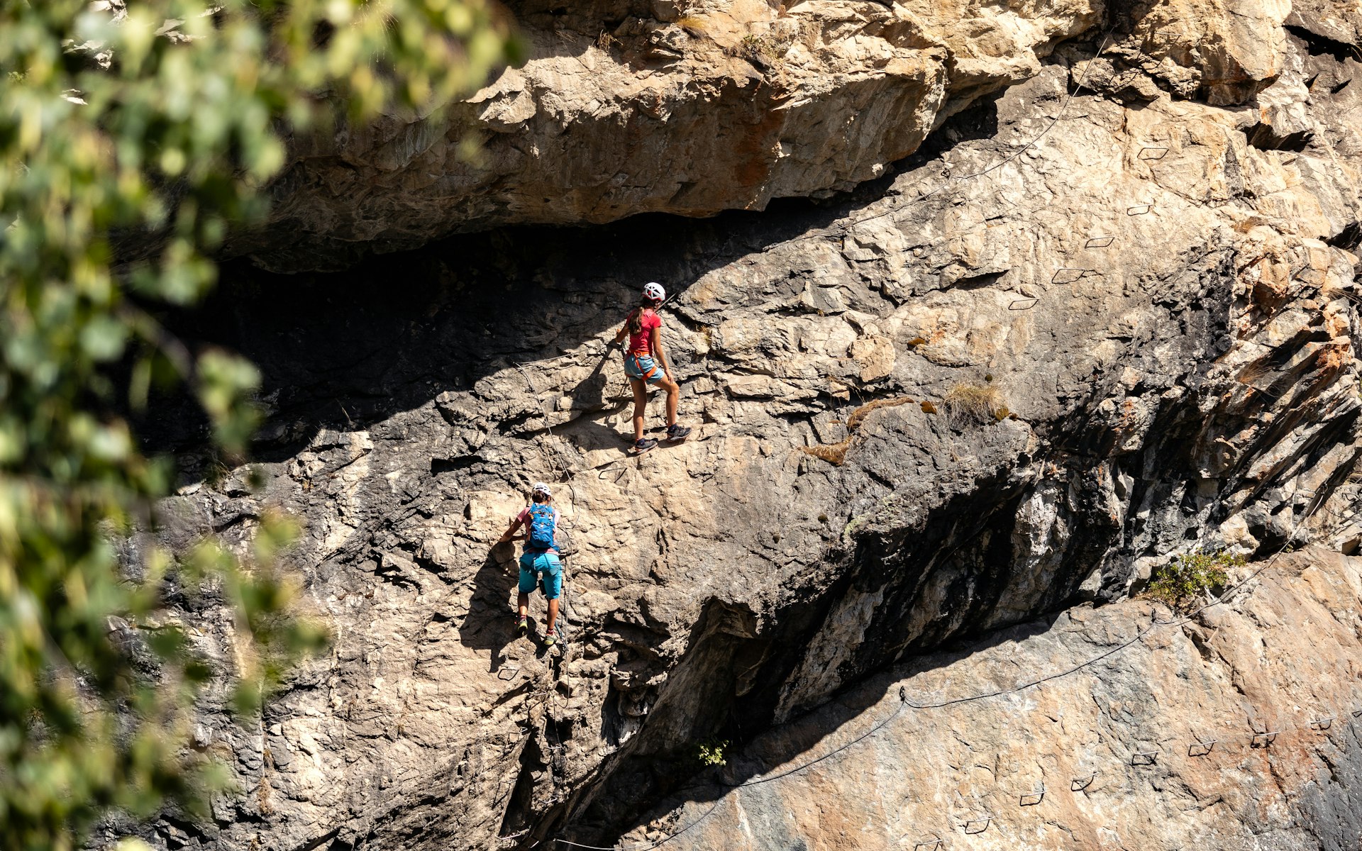 A group of people climbing up the side of a mountain